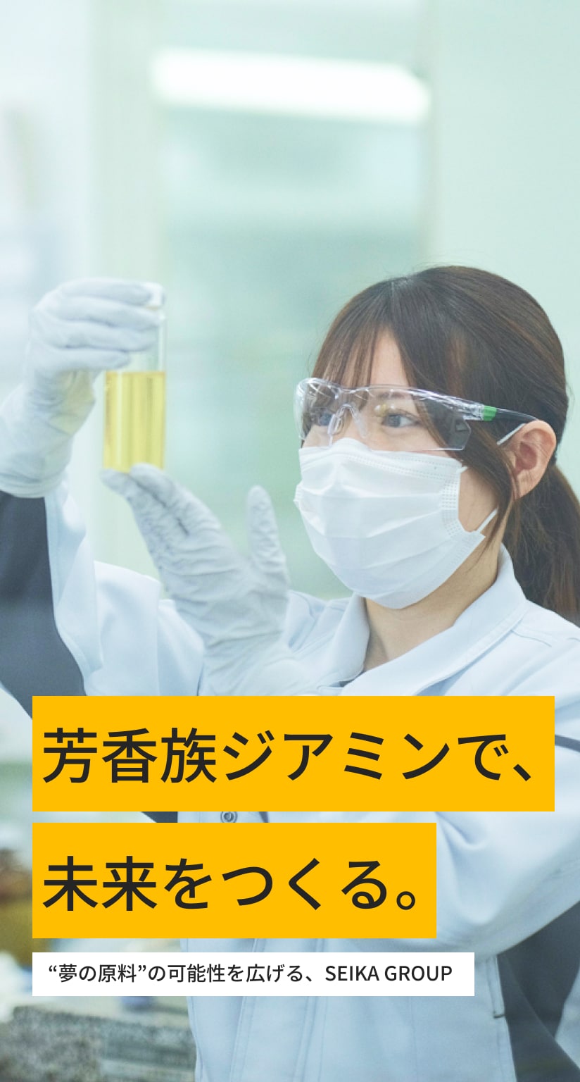 ガラス製の実験器具を扱う女性社員の写真。安全ゴーグルとマスク、ゴム手袋、ユニフォームを着用している