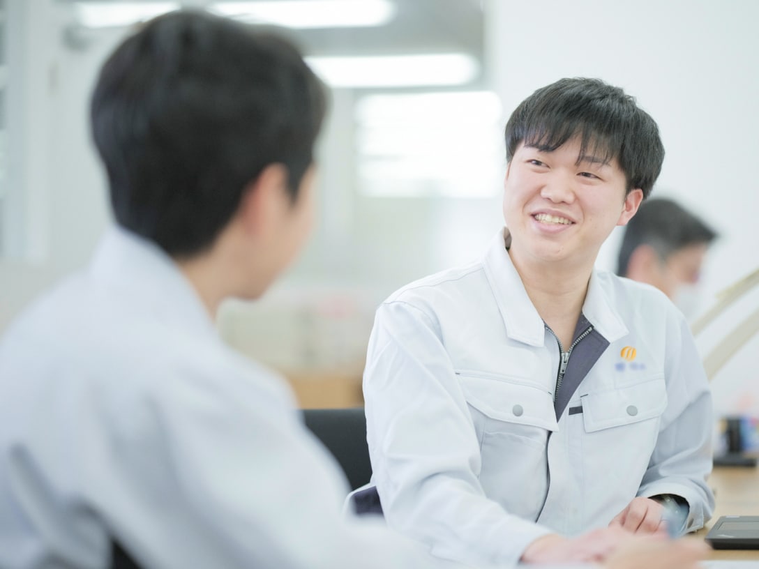 向かいの人物と笑顔で話しているT.Nさんの写真